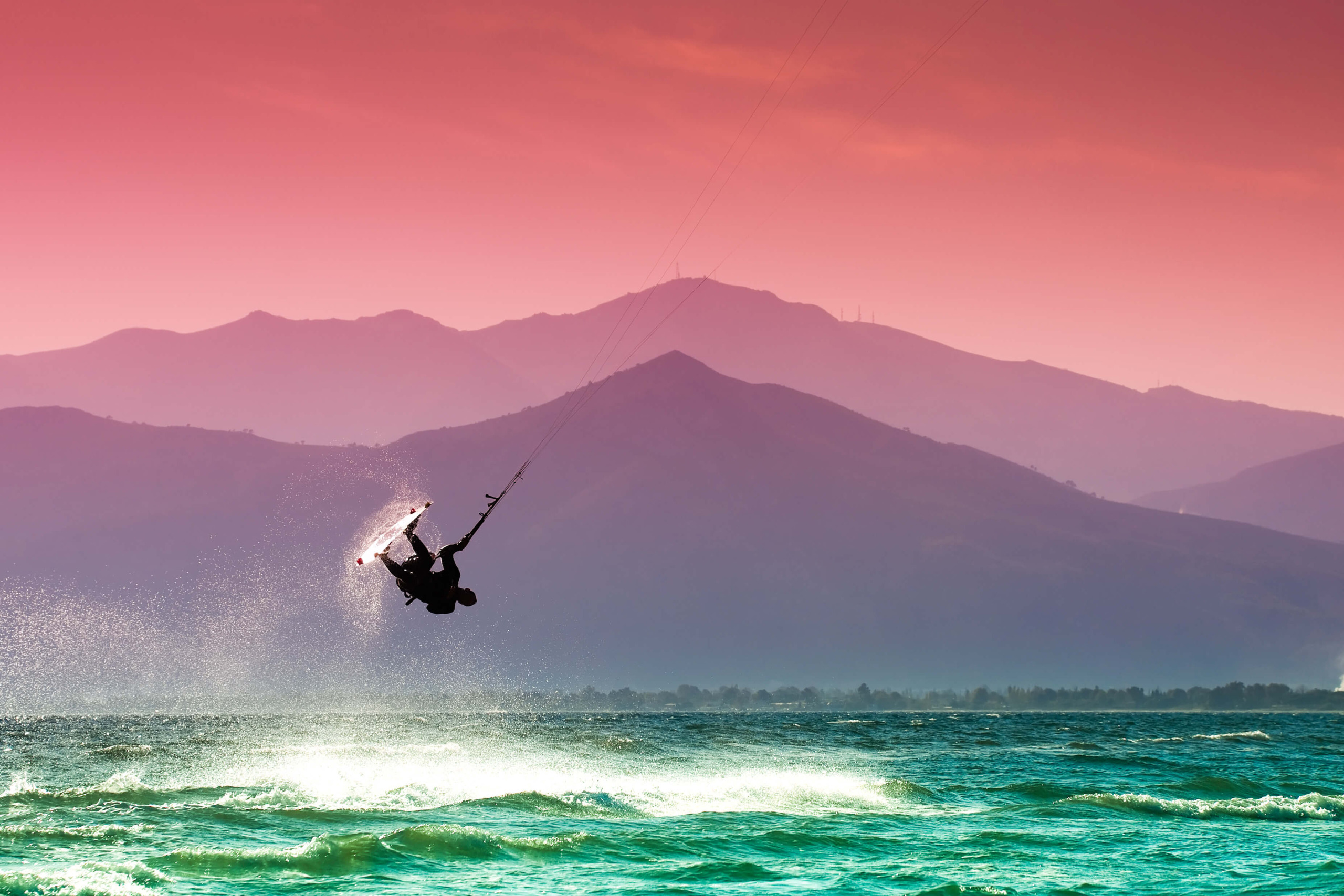 Kitesurfer riding waves at sunset